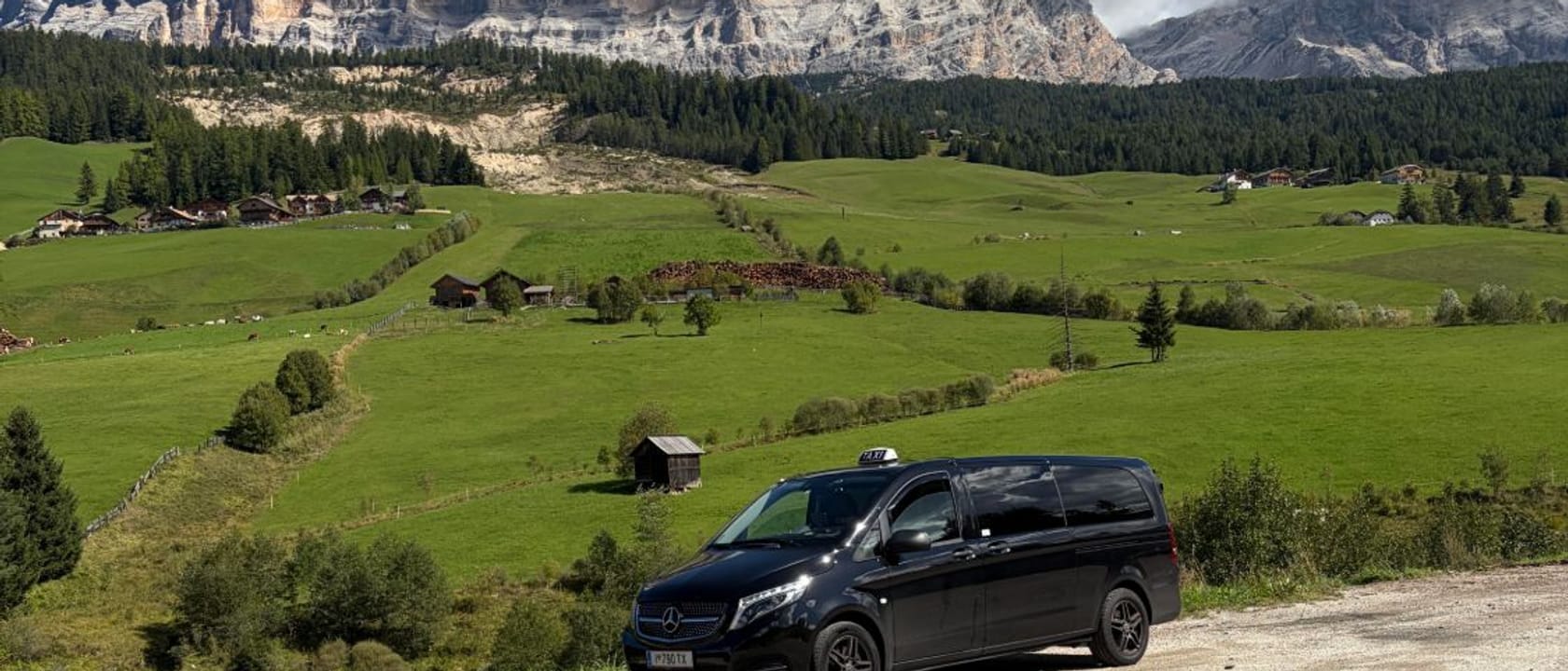 Mercedes V-Klasse von Taxi Fuchs auf einer Bergstraße vor den Dolomiten